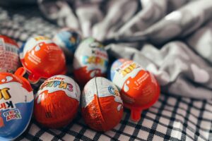 A collection of Kinder chocolate eggs on a textured blanket, perfect for festive treats or gifts.
